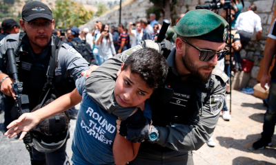 Israeli border guards detain a Palestini